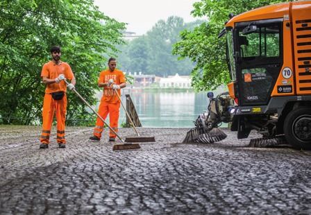 Zwei Parkreiniger kehren vor der traumhaften Kulisse am Weißen See