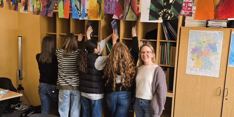 Schülerinnen der Klasse 6c räumen die neuen Fächer gemeinsam mit Schulleiterin Tabea Bartussek ein