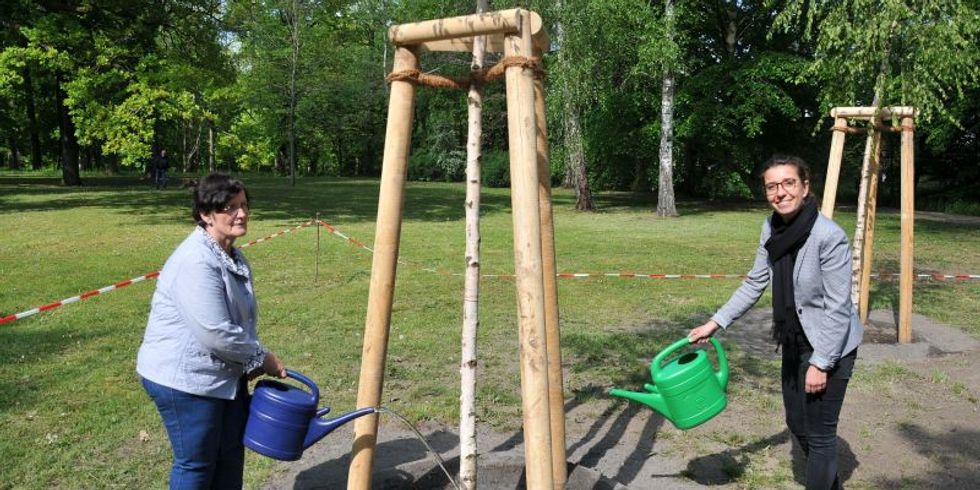 Dagmar Pohle und Nadja Zivkovic gießen einen frischgepflanzten Baum an