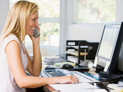 Frau sitzt am Schreibtisch und telefoniert