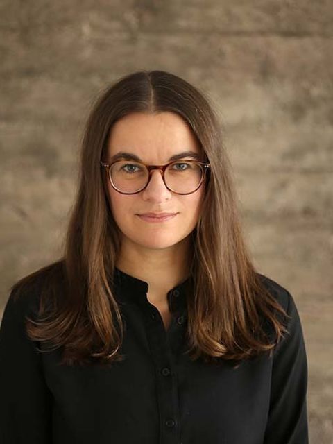 Portrait von Frau mit Brille (Berit Greinke) vor Stein-Hintergrund