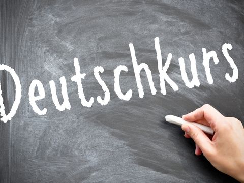 Graue Schiefertafel beschriftet mit Text Deutschkurs in weißer Kreide