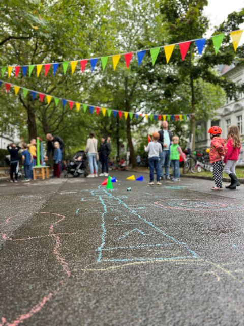 Farbenfrohes Spielvergnügen: Kinder spielen auf einer Straße im Rahmen des temporären Spielstraßenprojekts in Lichterfelde-Ost. (Bild: Bezirksamt Steglitz-Zehlendorf)