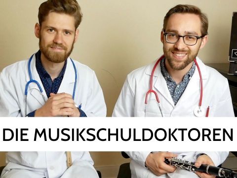 zwei Männer in weißen Kitteln mit Stetoskop und Klarinette