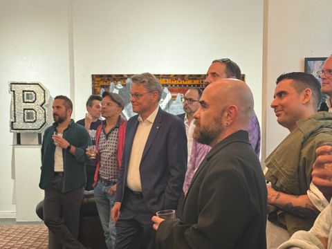 Versammelte stehende Menschen in einer Ausstellung