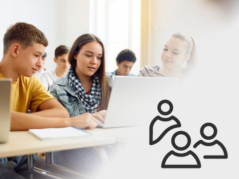 Drei Schüler schauen im Unterricht auf einen Laptop