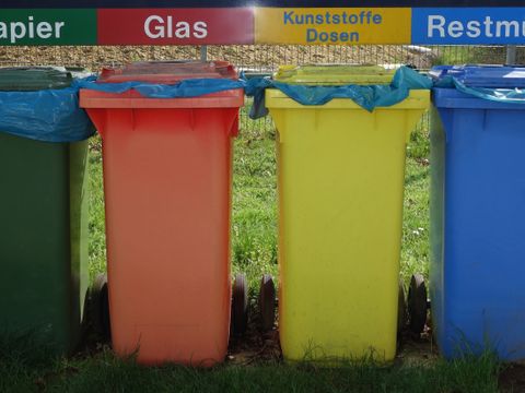 verschiedenfarbige Mülltonnen für Papier, Glas, Kunststoffe und Restmüll