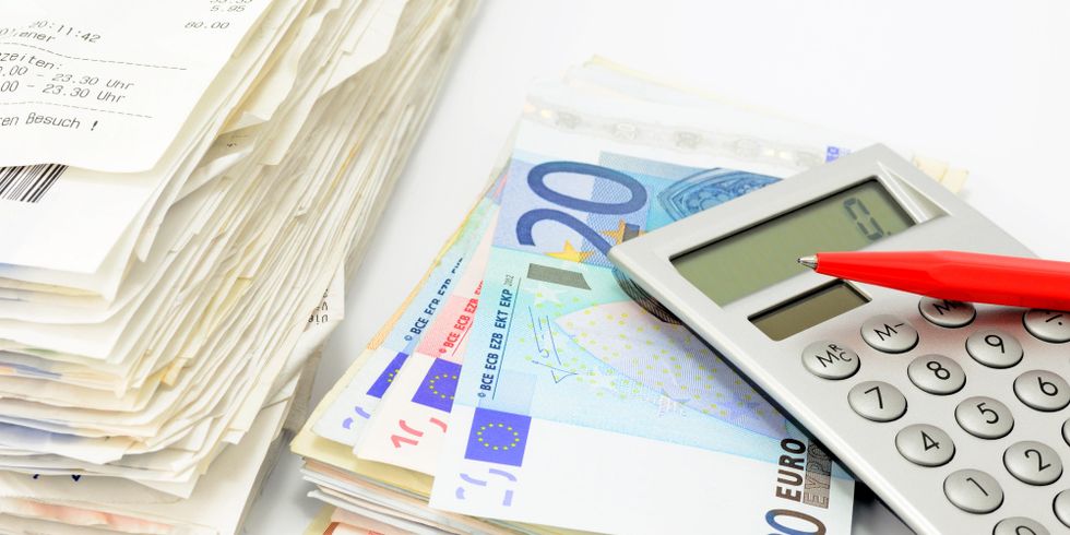 Das Bild zeigt einen Rechnungs- und einen Geldstapel mit Taschenrechner und Stift