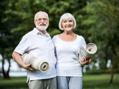 älteres Paar mit Yogamatten unter den Armen