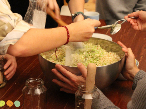 Bildausschnitt zeigt eine Salatschüssel und mehrere Hände, die gemeinsam ein Essen vorbereiten