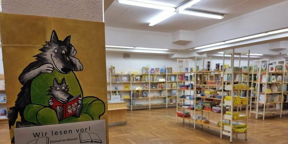 Foto der Biblitothek mit einem Schild "Wir lesen vor!"