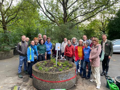 Gruppenbild vor dem neu bepflanzten Riesenblumentopf in der Dessauer Straße