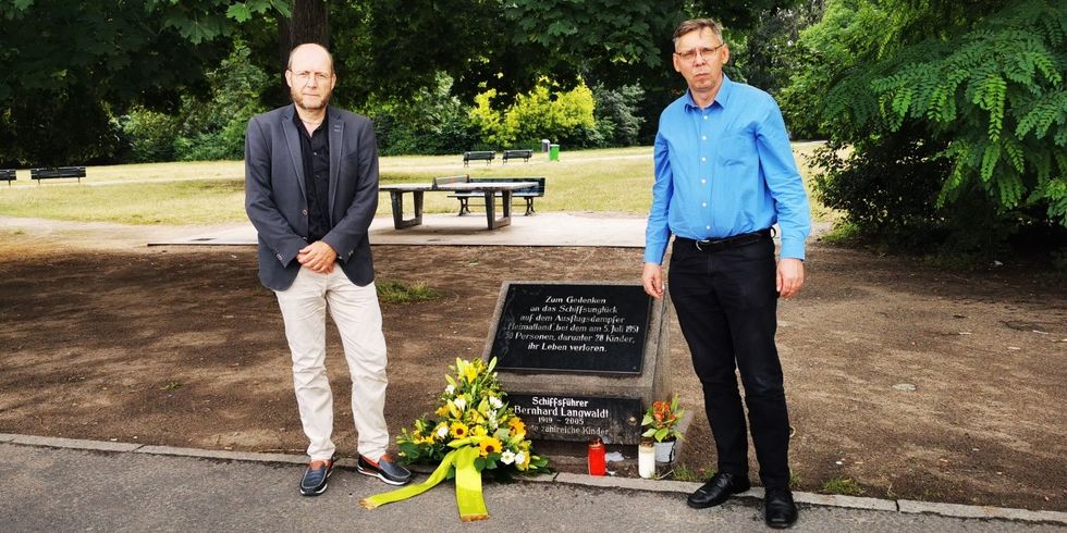 BVV-Vorsteher Groos und Stellvertretender Bezirksbürgermeister Klemm stehen am Gedenkstein zum Schiffsunglück im Treptower Hafen