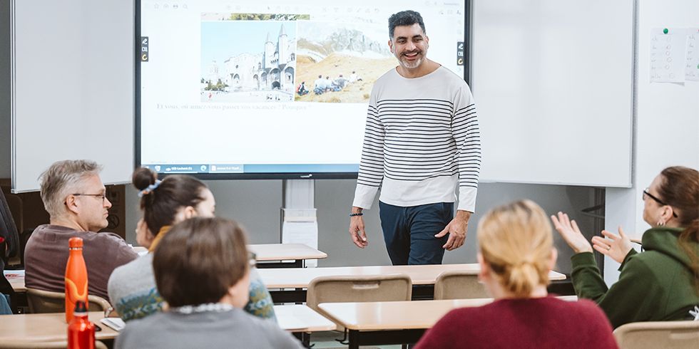 Kursleiter Yann-Nicolas Martial steht vor dem Whiteboar und interagiert mit der Gruppe