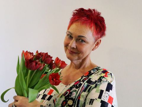 Frau Bahr vom Gratulationsdienst mit Blumenstrauß in der Hand