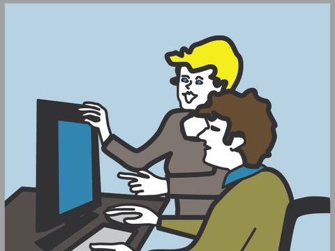 Frau unterstützt Mann mit Rollstuhl vor dem PC