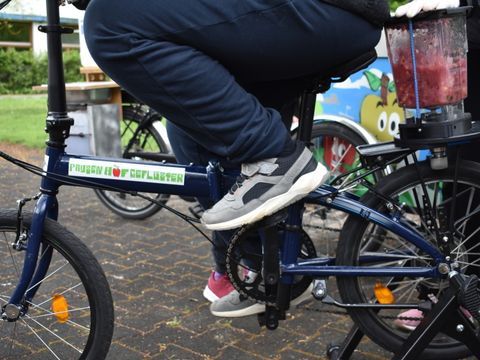 Ein Fahrrad mit der Aufschrift "Pausenhofgeflüster", auf dem Gepäckträger ist ein Smoothiemaker befestigt