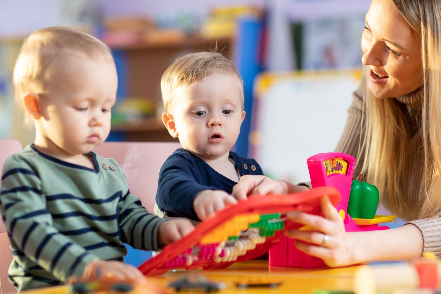 Erzieherin spielt mit zwei Kindern