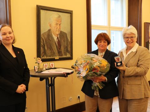 Bezirksbürgermeisterin Stefanie Remlinger und BVV-Vorsitzende Jelisaweta Kamm verleihen Bruni Wildenhein-Lauterbach die Bezirksverdienstmedaille