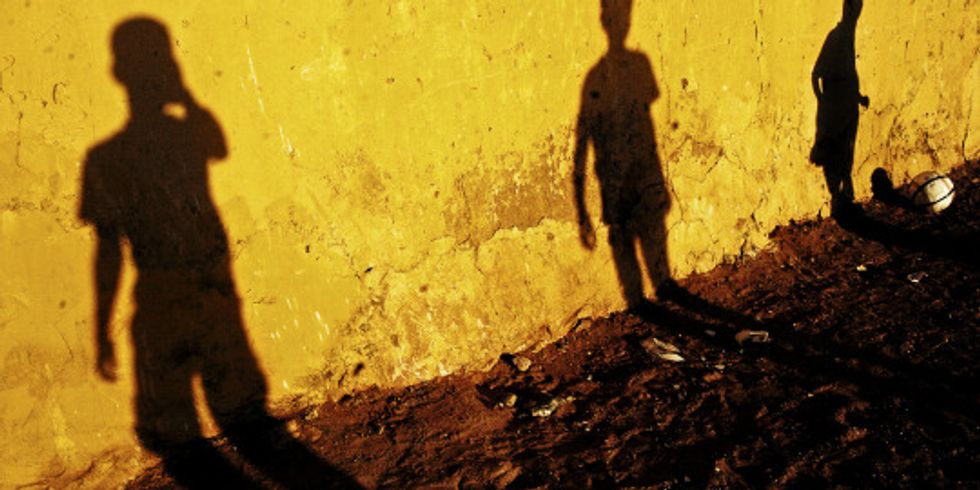 Schatten von Jugendlichen an Hauswand durch Sonnenlicht