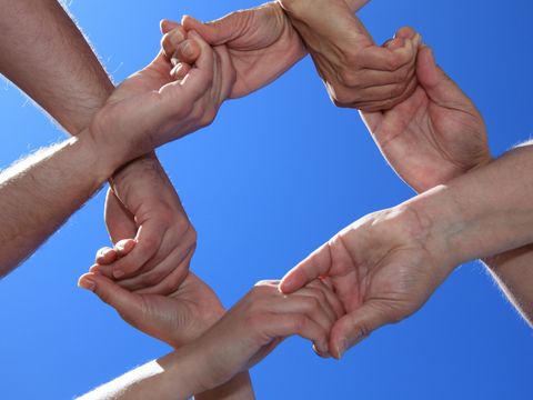 Hände mehrerer Menschen greifen ineinander
