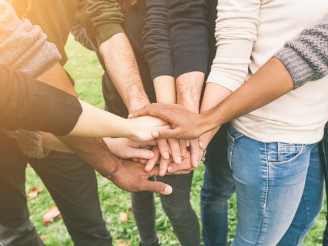 Freundesgruppe hält Hände in der Mitte zusammen