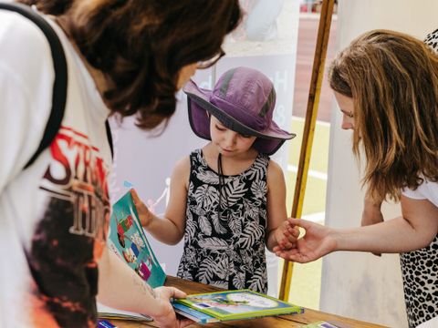 Bezirksbürgermeisterin Clara Herrmann (re) lässt sich von einer jungen Besucherin des Sportfestes ein Sammelhelftchen zeigen (Bild: Beata Sisak @beatasisakphotography)