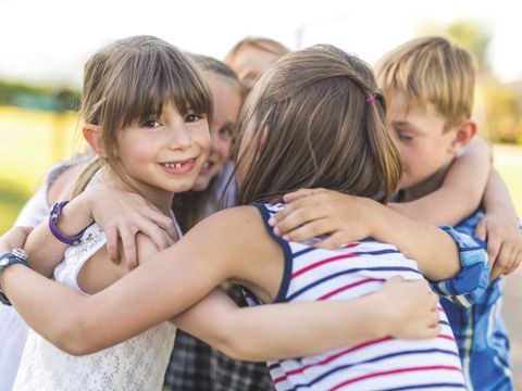 Kinder im Kreis mit Armen um die Schultern