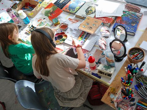 Zwei Schülerinnen sitzen an einem Tisch und zeichnen