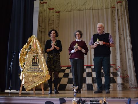Schulleiterin Fee Mergenthaler-Starke (l.) und die Schachleher Swantje Munsau und Harald Fietz mit der Auszeichnung Deutsche Schachschule in Gold