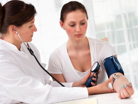 Ärztin misst den Blutdruck und Puls bei Patientin