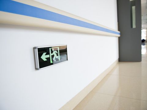 Krankenhausflur mit Hinweisschild für den Notausgang