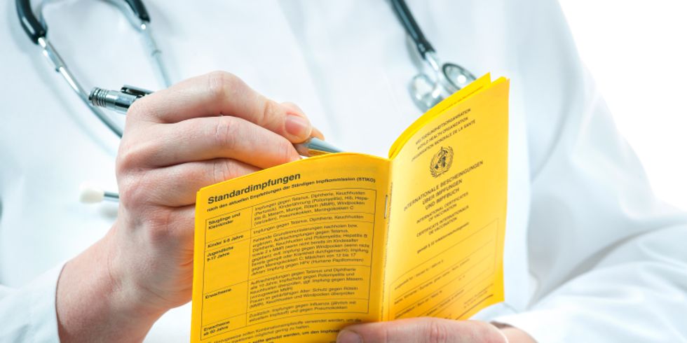 Arzt mit Impfpass in der Hand
