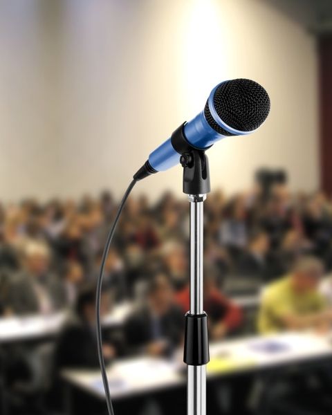 Mikrofon vor einem Hörsaal mit Menschen