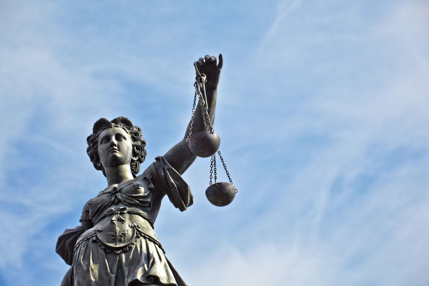 Skulptur von Themis, Femida oder Gerechtigkeit Göttin auf strahlend blauem Himmel