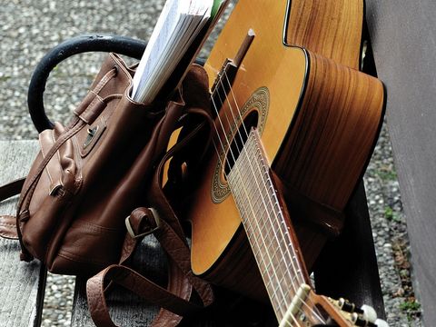 Gitarre und Rucksack auf einer Bank