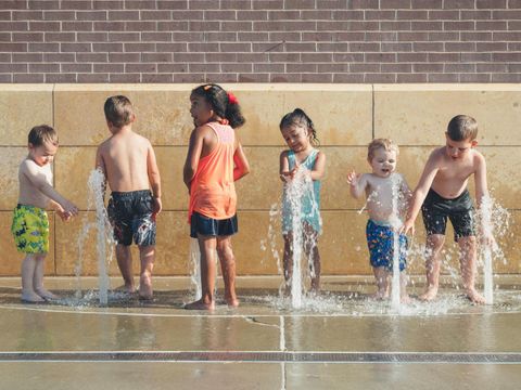 Kinder beim Wasserspiel an Springbrunnen
