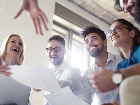 Personen in einer Runde freuen sich über Ihre Zusammenarbeit