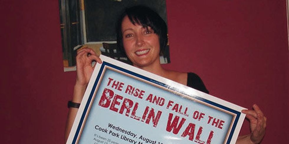 Anette Isaacs mit Poster zum Mauerjubiläum