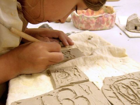 Keramik I & II: Ein Kind arbeitet mit Ton.