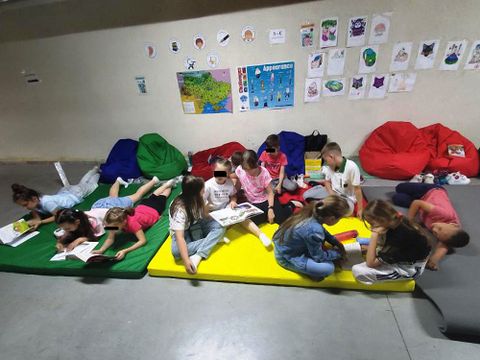 Kinder lesen in einem Schutzraum in Kyjiw-Darnyzja