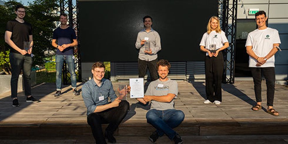 Gewinner:innen stehen verteilt auf Bühne und halten ihre Awards und Urkunden hoch
