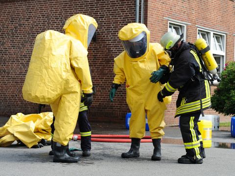 Drei Feuerwehrleute in Schutzanzügen