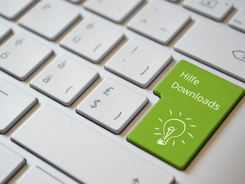 Computertastatur mit grüner Taste beschriftet mit "Hilfe, Downloads"