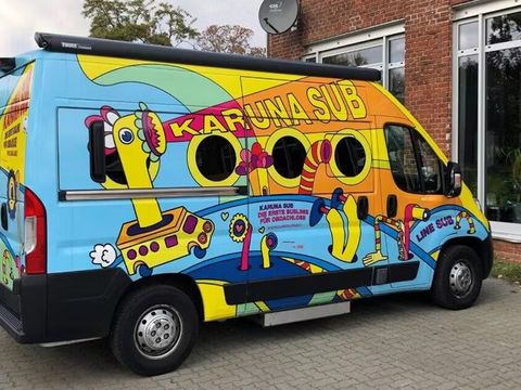ein mit Graffiti beschrifteter Bus mit der Aufschrift Karuna SUB