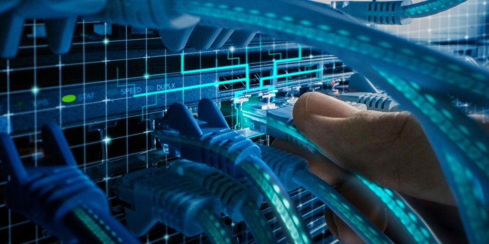 Makroaufnahme mit erweiterter Realität: IT-Administrator steckt den RJ45-Internetanschluss in einen LAN-Router-Switch. Kabel mit virtuellen Grafiken, die Daten anzeigen