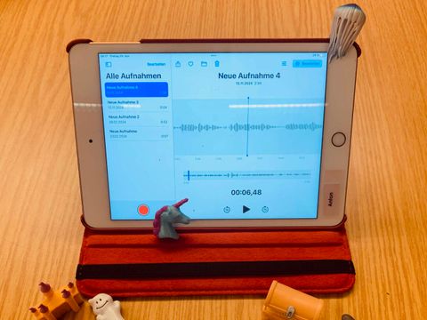 Tablet mit geöffnetem Sound-Programm umgeben von Spielfiguren