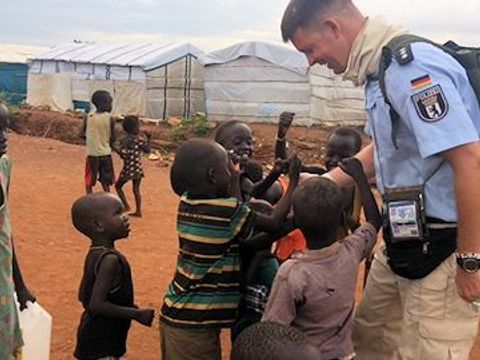 Polizeibeamter mit Kindern in einem Lager in Afrika