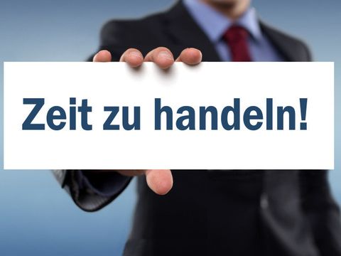 Mann hält Schild hoch mit der Aufschrift "Zeit zu Handeln"