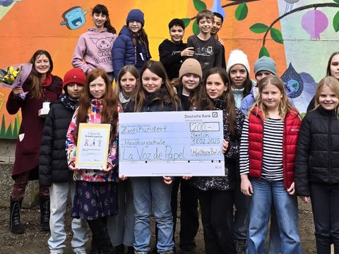 Die Schüler*innen der Friedrichshainer Hausburgschule zeigen den Gewinner*innen-Scheck über 200 Euro, den sie für ihre Schülerzeitungs-Arbeit erhalten haben